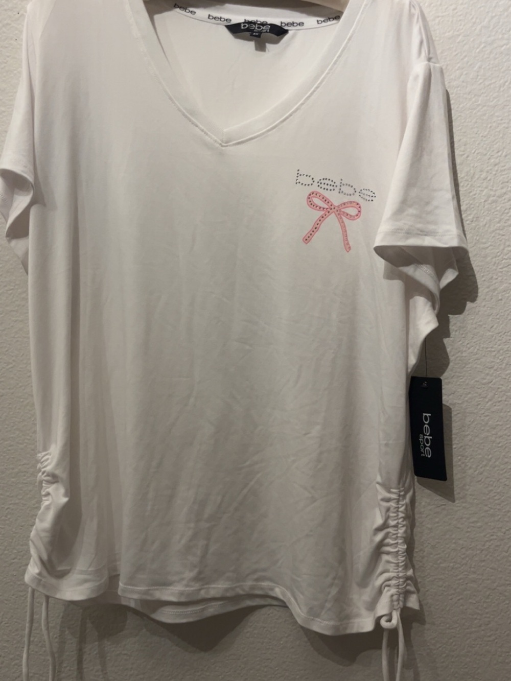 bebe White V‑Neck Tee with Pink Bow Accent